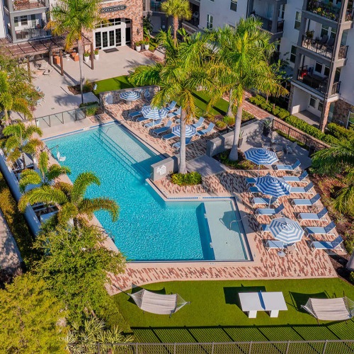 outdoor pool with umbrella shaded lounge chairs