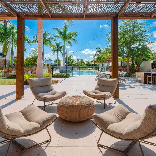 partially shaded lounge with plush chairs and wicker table