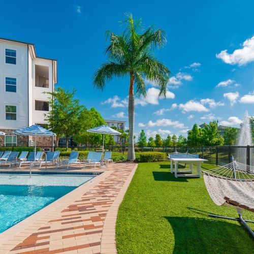 gated pool with hammock lawn next to pond