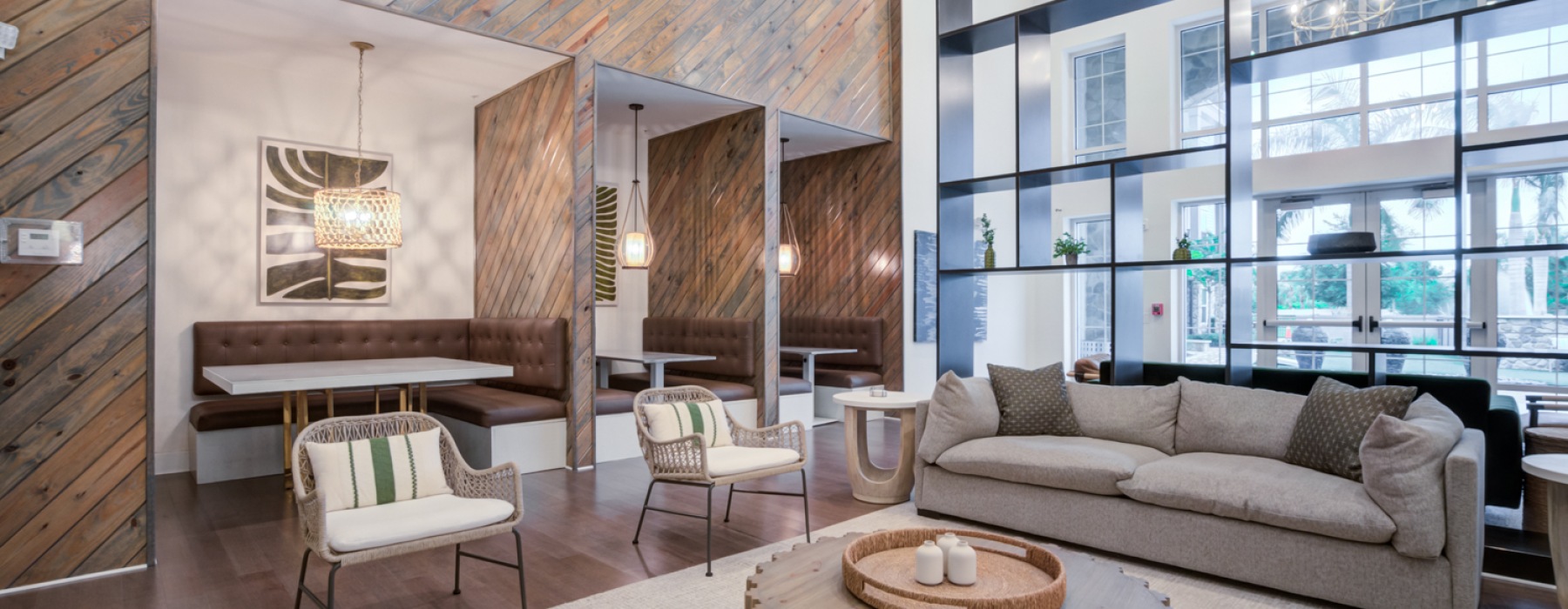 Beautiful clubhouse with couch, private working booths, and views of the pool area